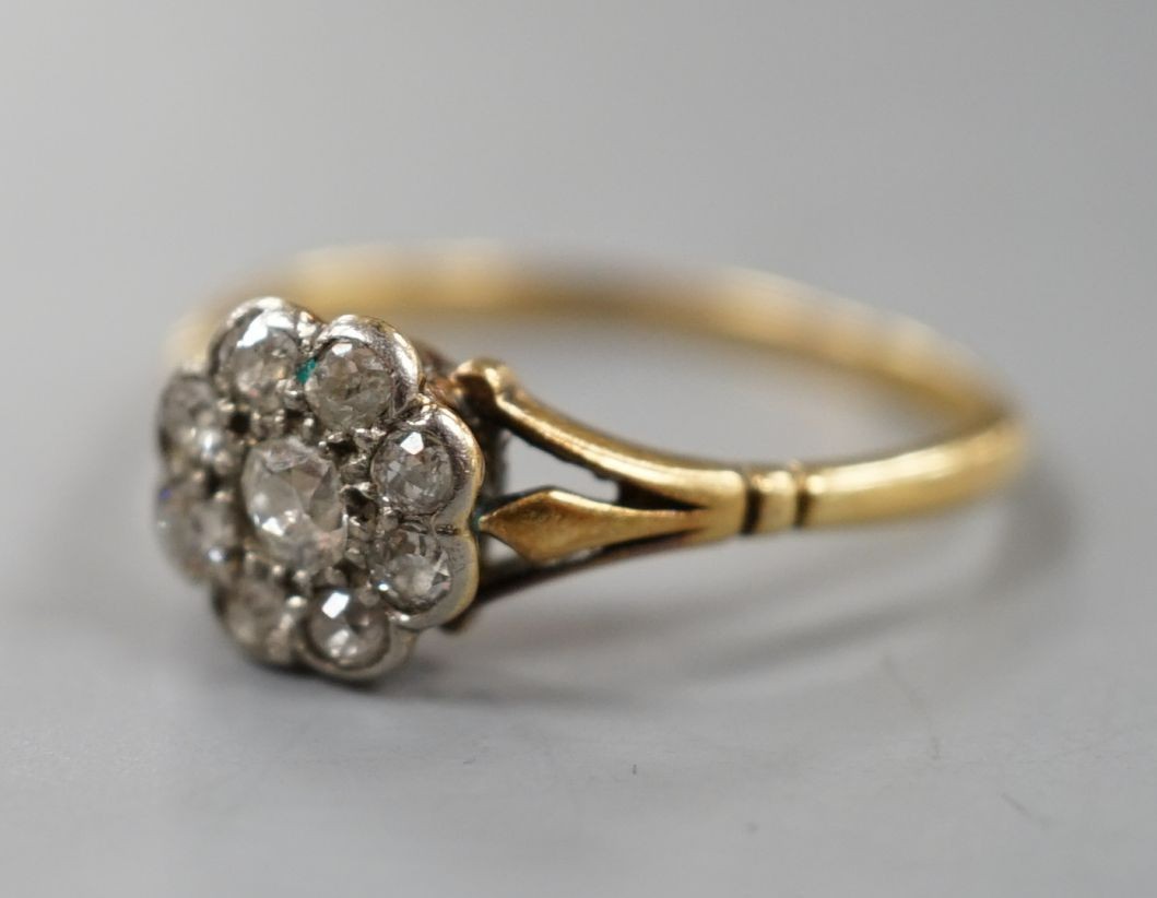 A yellow metal and nine stone diamond set flower head cluster ring, size Q